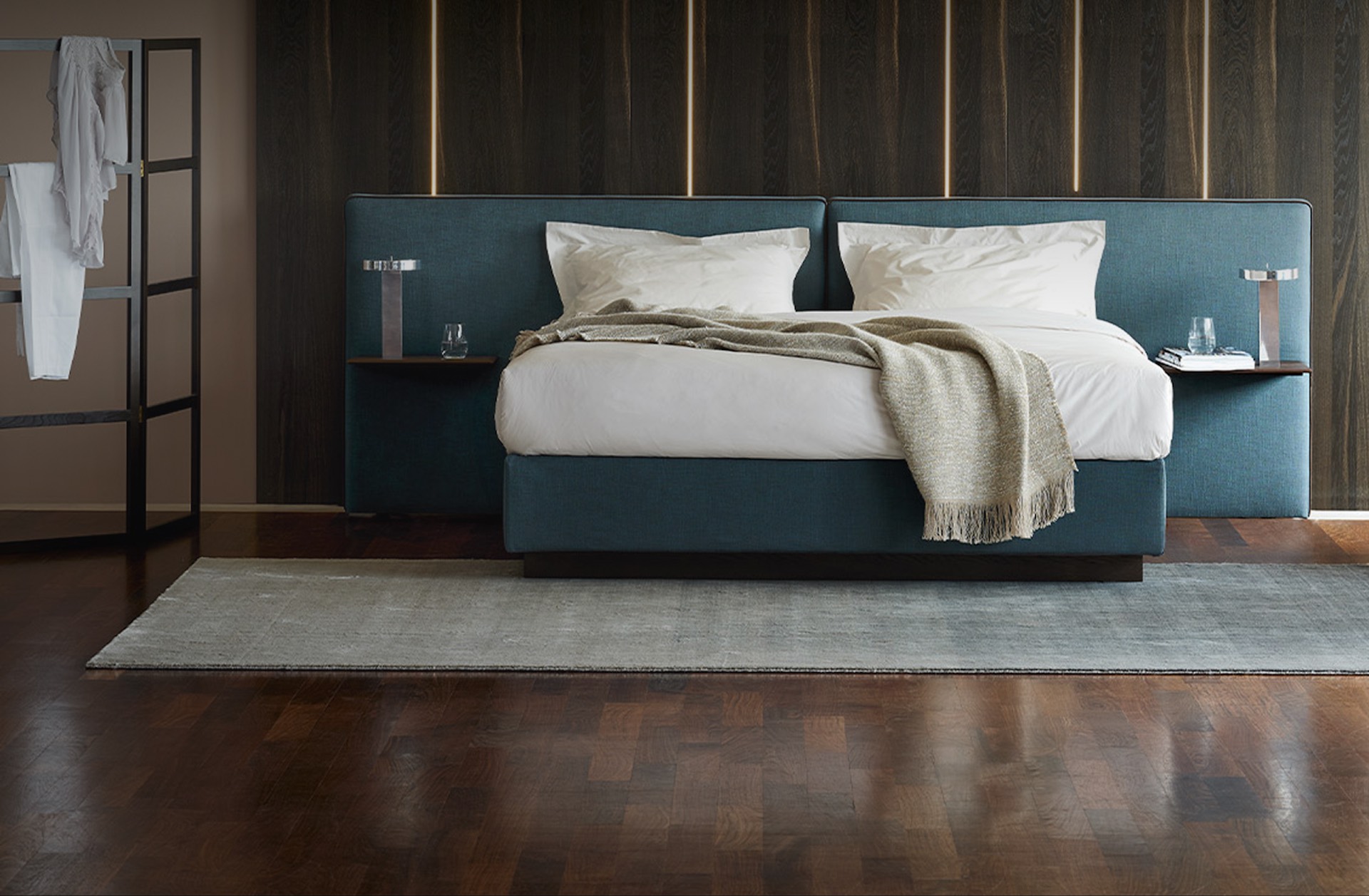 Vispring Bett mit petrolblauem Kopfteil vor dunkler Holzvertäfelung